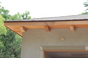 The pickups (wood brackets) above the garage.  The little square is part of one of the original bricks. 