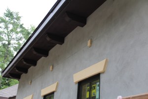 The wood trim has been stained (those decorative pieces under the eaves are called lookouts). Hopefully by this tie next week we won't see the grey stucco anymore!