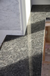 The master tub deck meets the marble shower walls